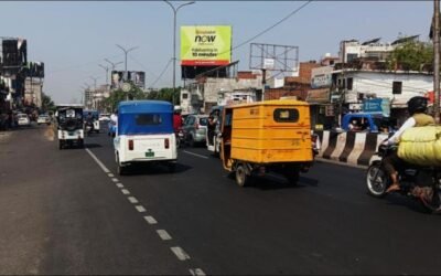 High-Traffic Billboard by Hoarding Advertising Companies in Lucknow – Prime Urban Location Billboard placed by hoarding advertising companies in Lucknow on a crowded commercial road with autos, bikes, and daily commuter traffic.