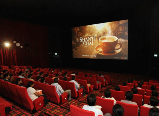 Shanti Chai – Warmth in Every Sip | Cinema Ad Spotlight Audience in a cinema theater watching a Shanti Chai cinema ad with steaming tea and the tagline Warmth in Every Sip.